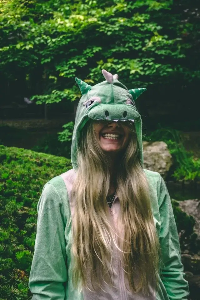 A happy, healthy stoner girl in a dragon onesie laughing while high and getting productive things done.