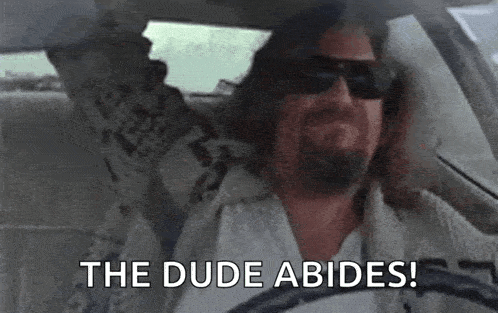 A GIF of The Dude from The Big Lebowski driving a car and living his best life as a stoner, with the text overlay 'The Dude Abides!'.